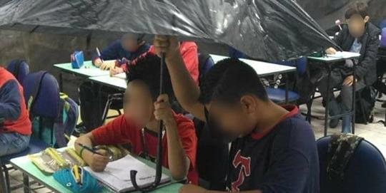Alunos utilizaram um guarda-chuva para se proteger das coteiras da sala de aula