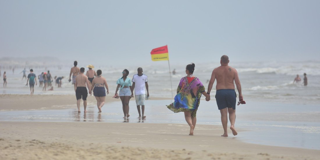 Veranistas aproveitaram sábado nublado para caminhar na beira da praia em Imbé