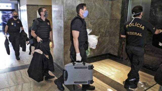 Policias federais carregam material apreendido na Operação Placebo, no Rio de Janeiro, que apura desvio de verbas de combate ao coronavírus no estado.