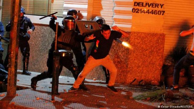 Policiais agridem manifestante: houve um morto e 18 feridos nos confrontos